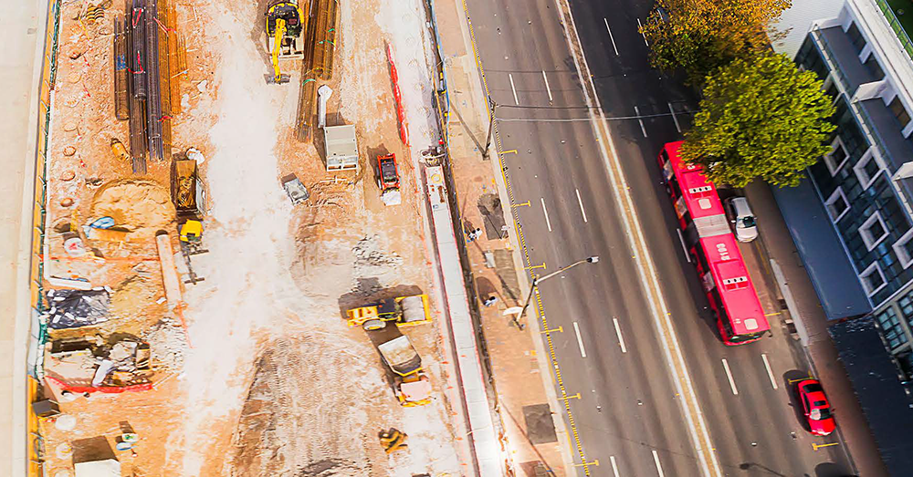 Drone shot of construction taking place next to a road.