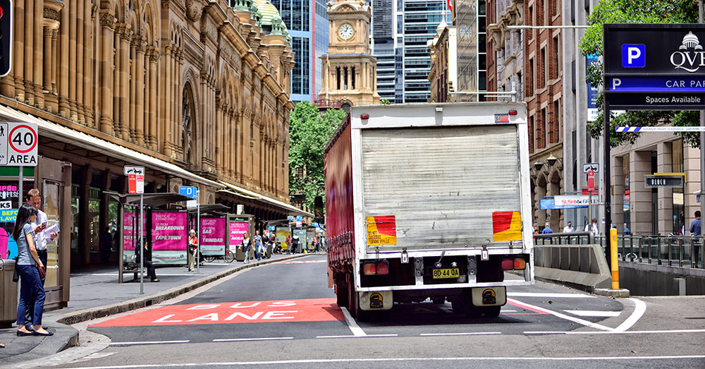 A freight van turns into a Sydney city street near the QVB Building.