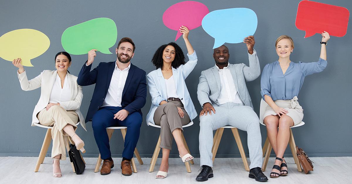 Five people seated in a row holding colourful speech bubbles above their heads, representing discussion, consultation, feedback and community engagement.