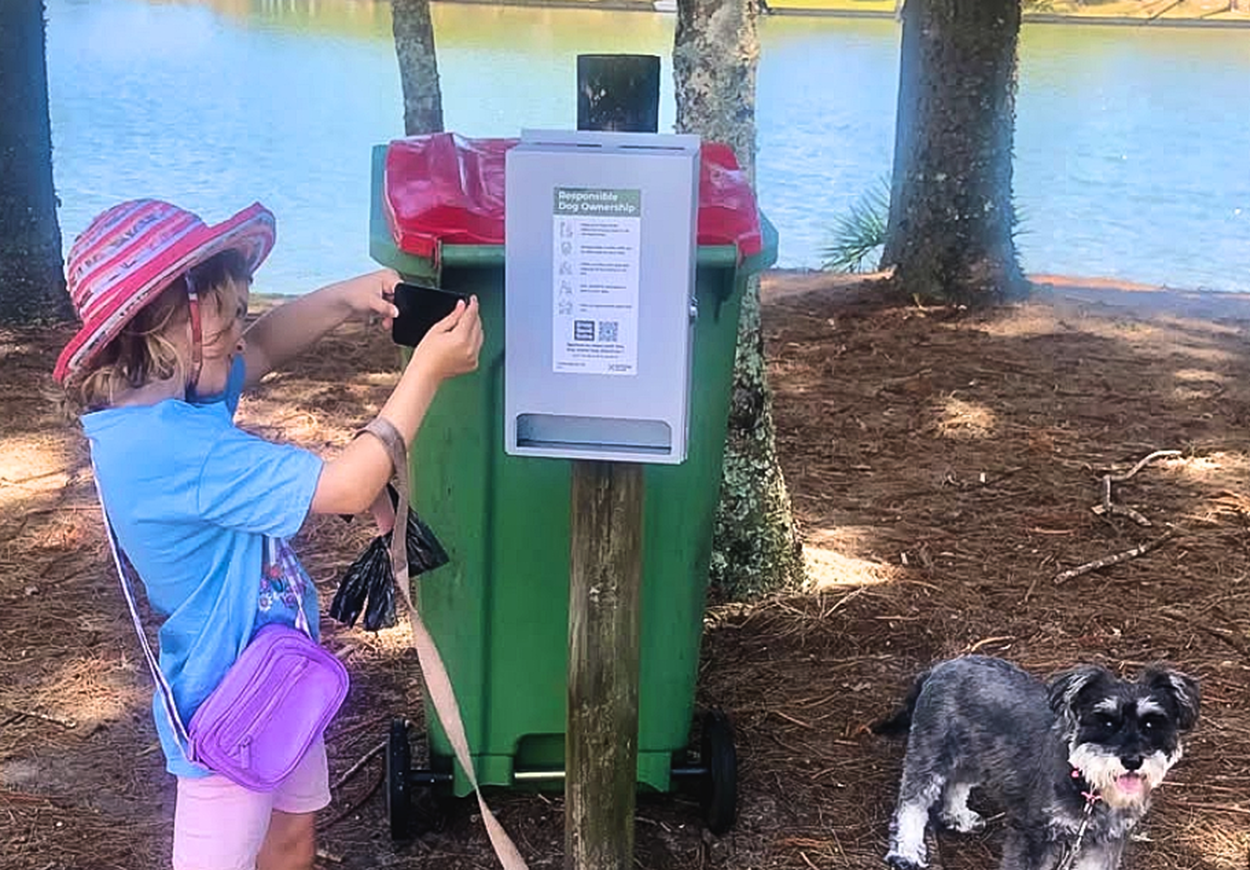 A child uses a smartphone to scan a Snap Send Solve QR code.