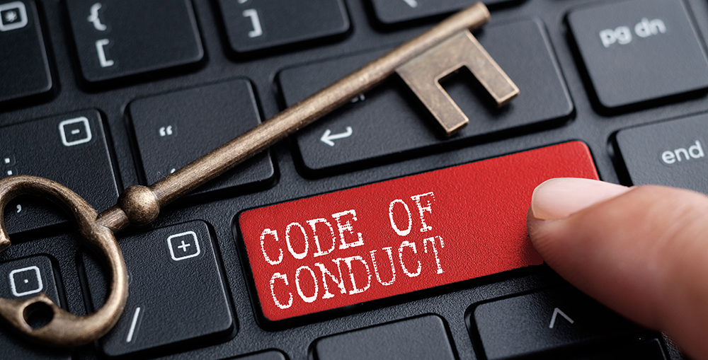 A keyboard with one of the keys highlighted in red, "Code of Conduct"