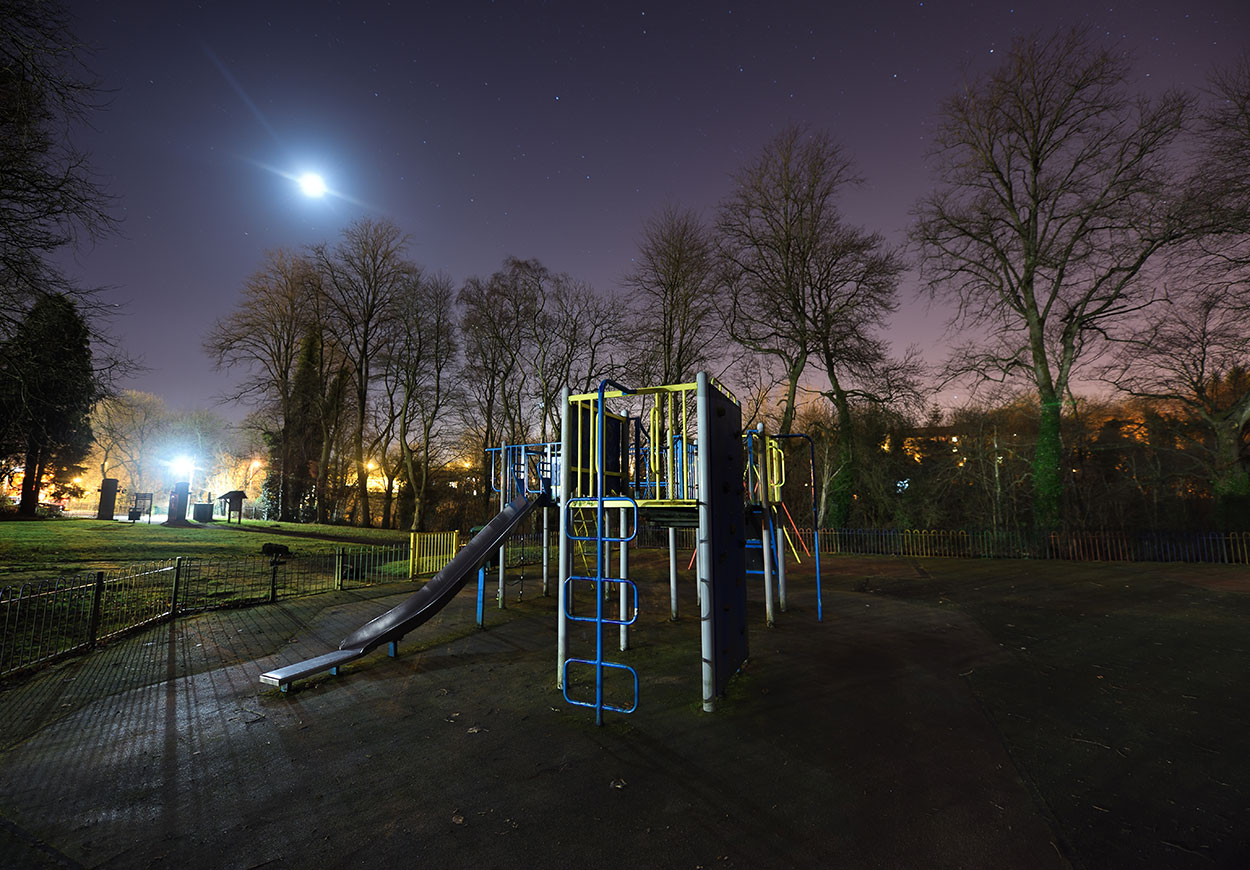A children's playground at night.