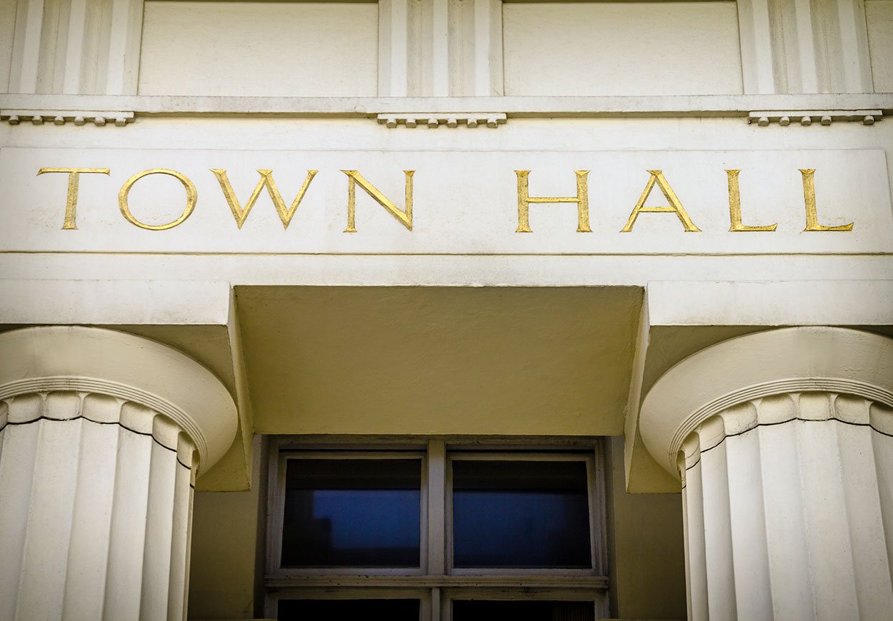 An impressive building with columns and above the doorway reads "Town Hall".