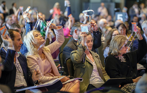 Delegates at the 2023 Annual Conference vote on a motion.