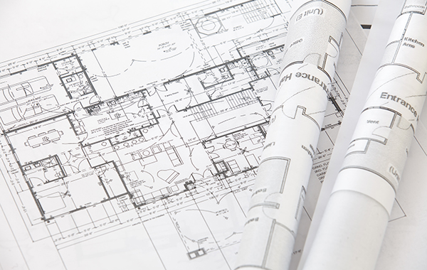 A set of plans unfurled on a desk.
